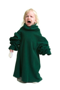 crying toddler in green shirt that's too big