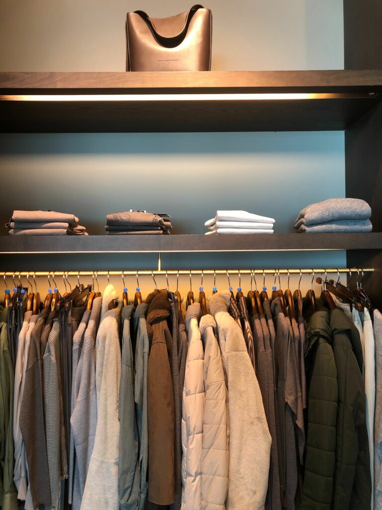 folded shirts and hanging jackets in a closet