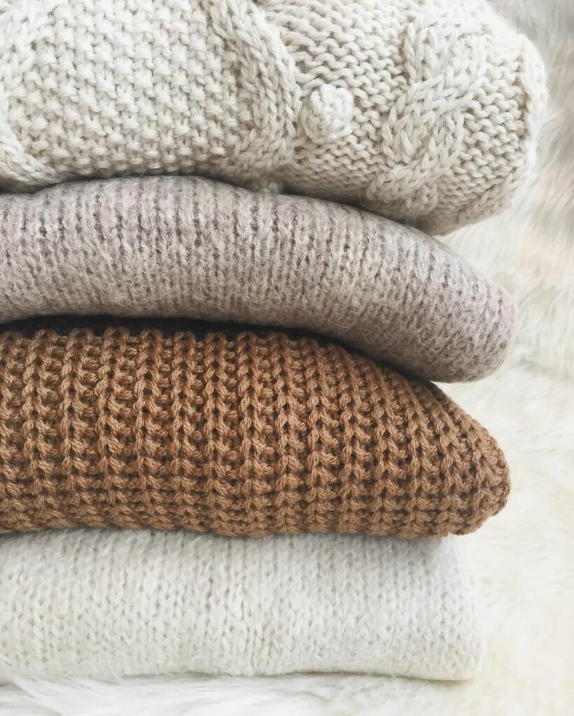 stack of brown and white sweaters