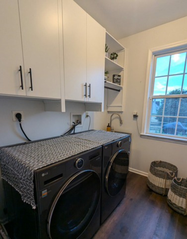 Laundry room storage with shelves and doors over washer dryer