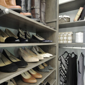 Corner of walk-in closet in Driftwood color with shoe and boot shelving
