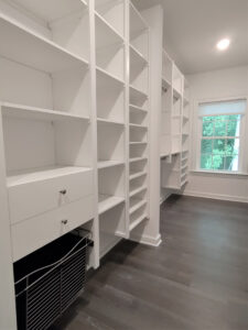 Image of a wall within a walk-in closet that has a taller height closet system.