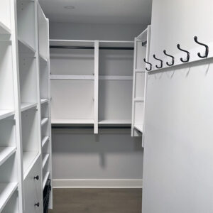 Wall hooks on the right side of a narrow walk-in closet